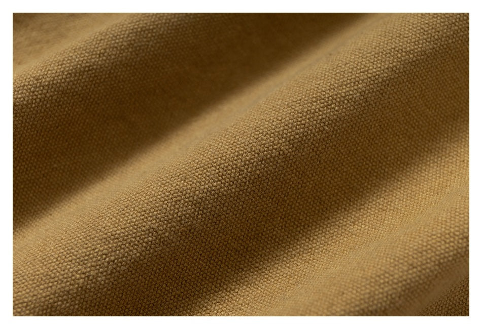 Extreme close-up showing the textured weave and folds of mustard-brown fabric.
