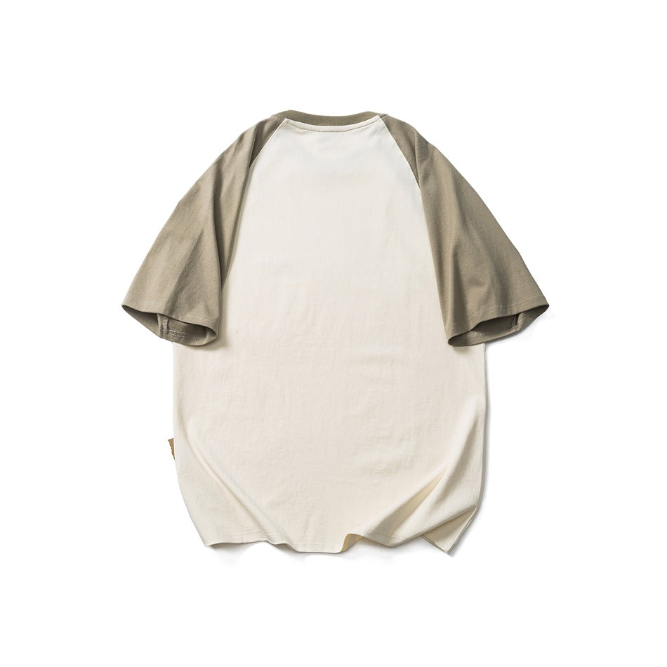 Back view of cream raglan T-shirt with gray-green sleeves and collar, flat lay