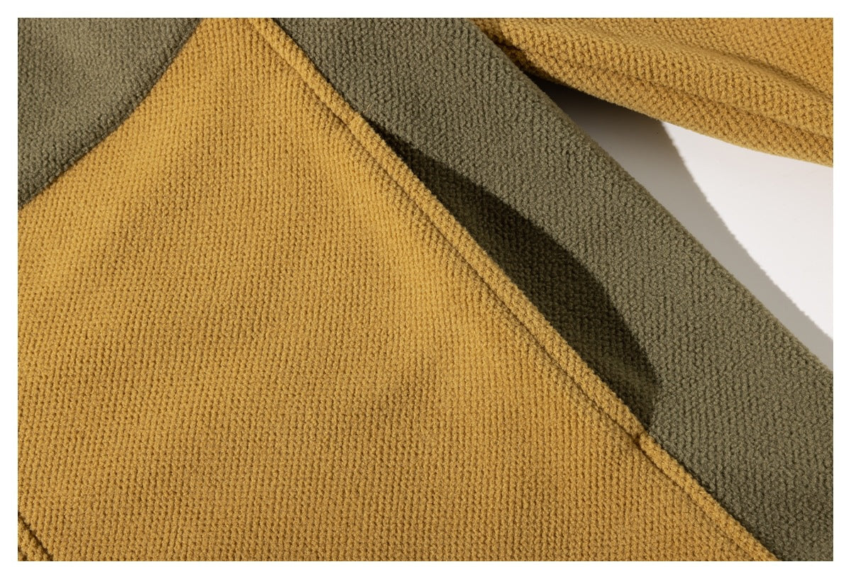 Close-up of mustard and olive jacket panels meeting at a diagonal seam.