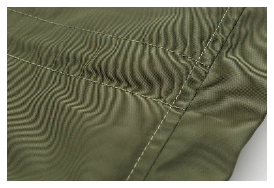 Close-up of olive fabric with parallel stitched seams and a reinforced edge.