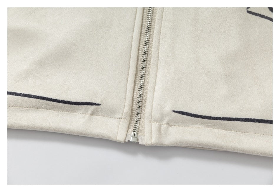 Close-up of an ivory garment with a silver zipper and thin black printed lines near the hem.