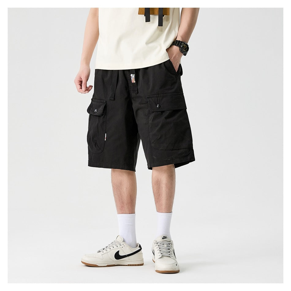 Model wearing black cargo shorts with a drawstring waist and large flap pockets, shown from the front.