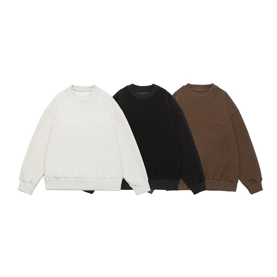Three textured crewneck sweaters shown together in off-white, black, and brown.