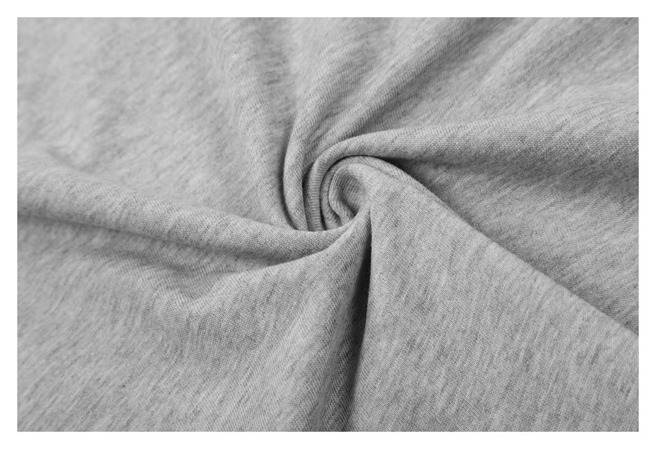 Close-up of light gray knit fabric gathered into a twist, showing its texture.