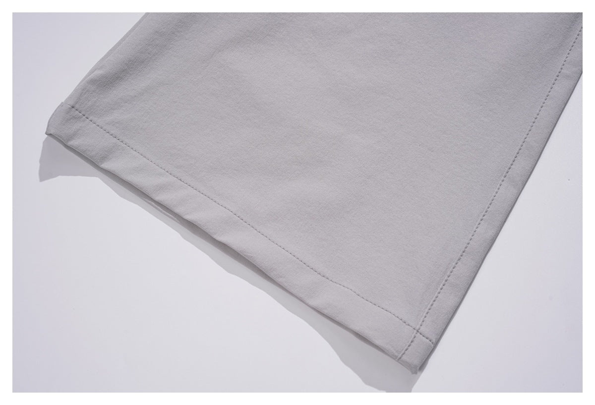 Close-up of a light gray trouser leg showing its stitched hem and side seam.