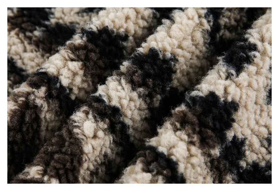 Close-up of thick, curly pile in a mottled cream, black, and dark brown pattern.