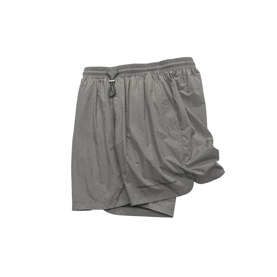 Front view of gray shorts with a gathered drawstring waist, side pockets, and loose, wide legs.