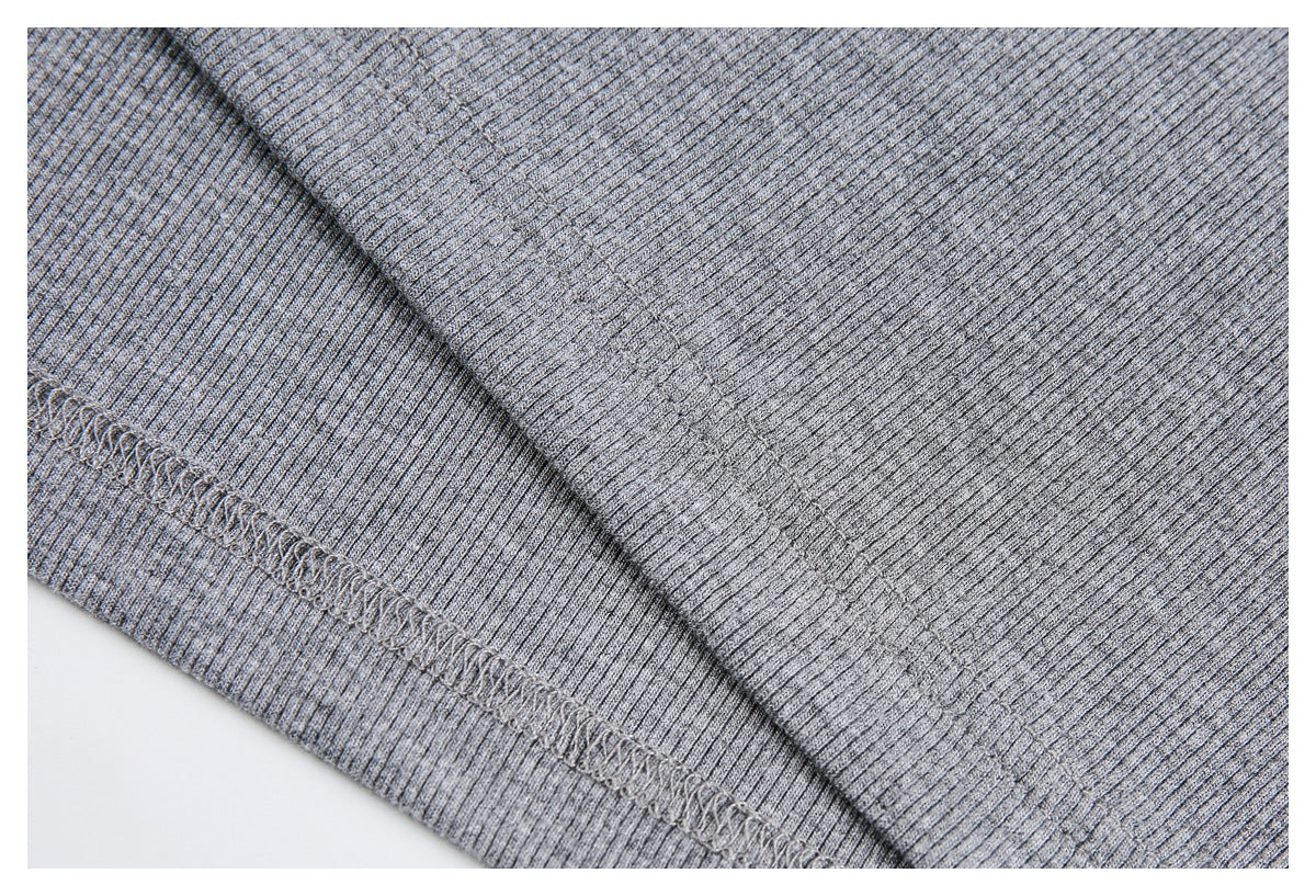Close-up of gray rib-knit fabric showing a diagonal overlock seam and fine vertical ribs.