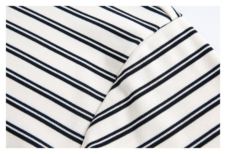 Close-up of the shoulder seam and sleeve on a white shirt with thin navy stripes.