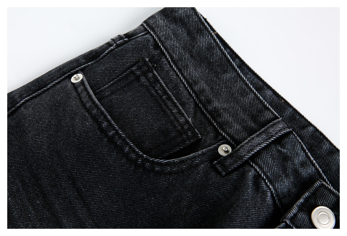 Close-up of a front pocket, belt loop and waistband on black denim jeans.
