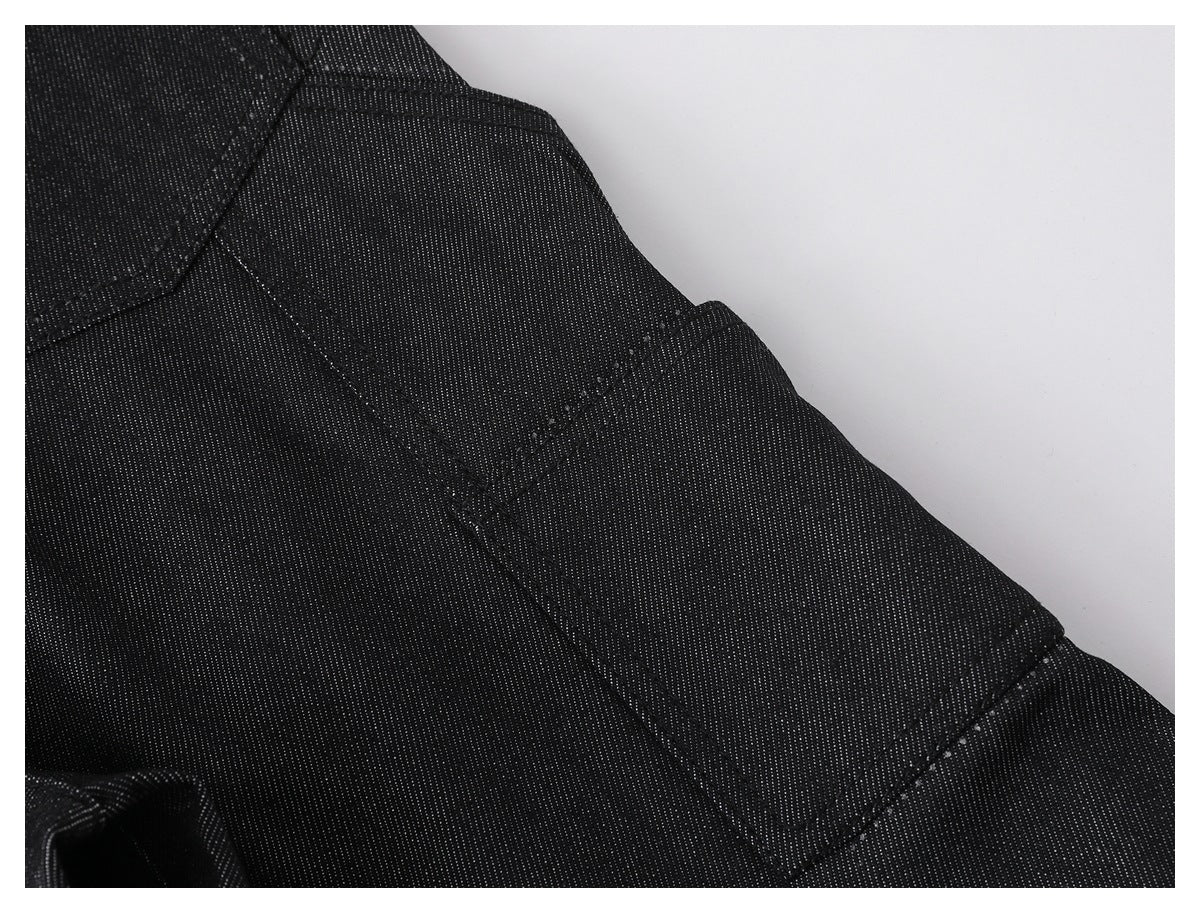 Close-up of black pants showing a curved seam and stitched panel details.