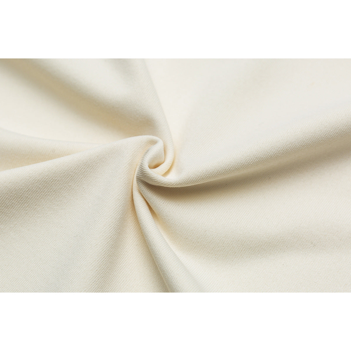 Close-up of ivory sweatshirt fabric gathered into a soft twist.