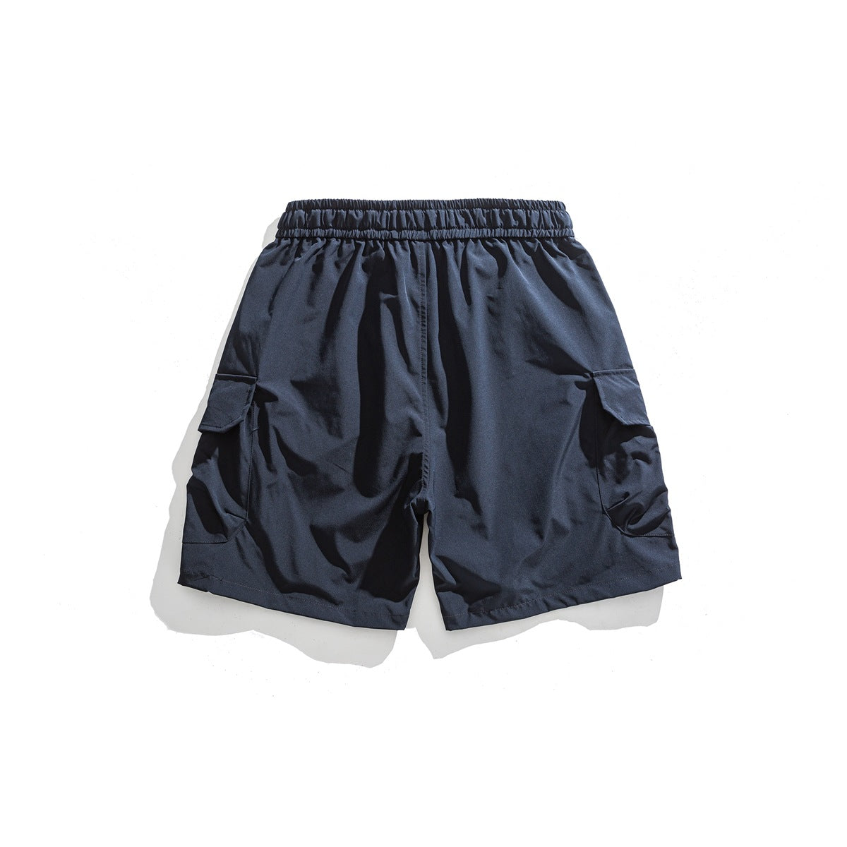 Back view of navy cargo shorts with an elastic waistband and flap pockets at the sides.
