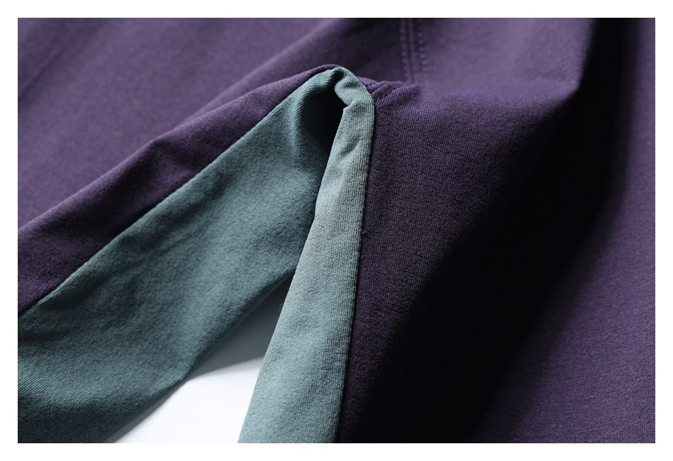 Close-up of the purple sweatshirt sleeve and muted teal inner cuff fabric.