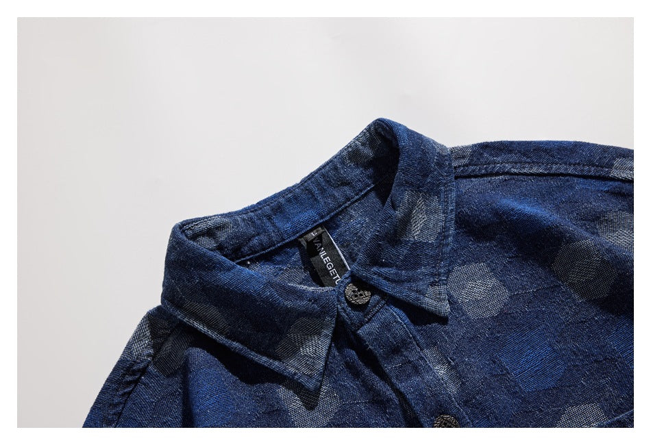 Close-up of the dark blue patterned shirt collar, button, and inner neck label.