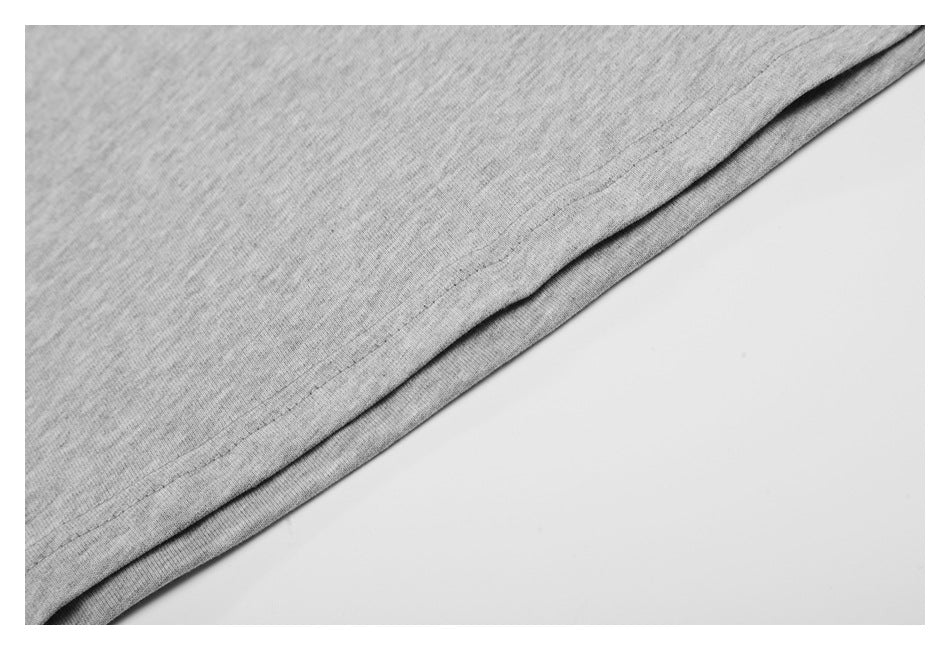 Close-up of the double-stitched bottom hem on heather gray T-shirt fabric.