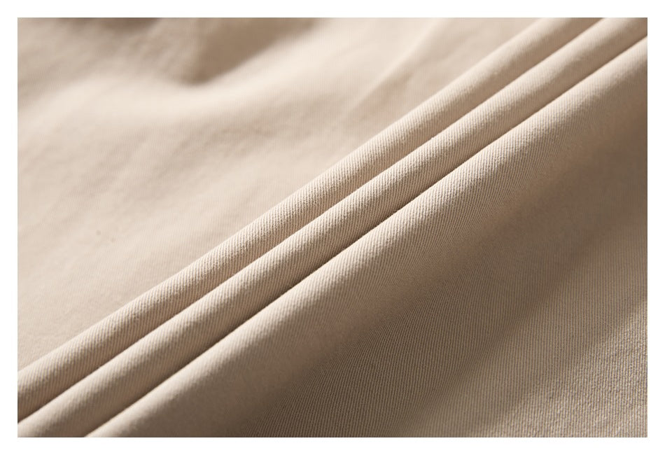 Macro view of beige shirt fabric gathered into soft folds.