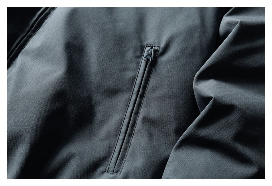 Close-up of a vertical zip pocket on the charcoal gray jacket.
