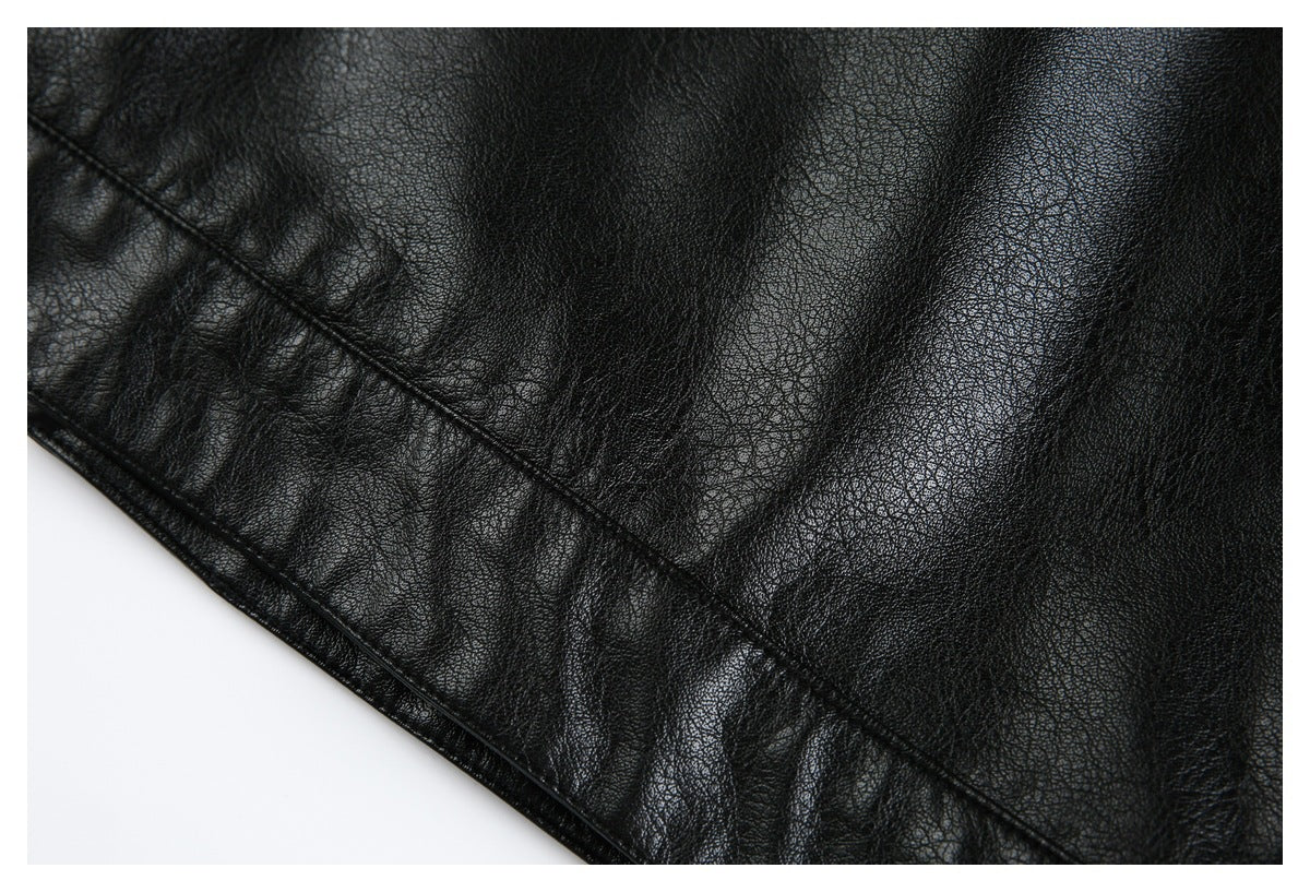 Close-up of black pebbled jacket material and a curved stitched edge.