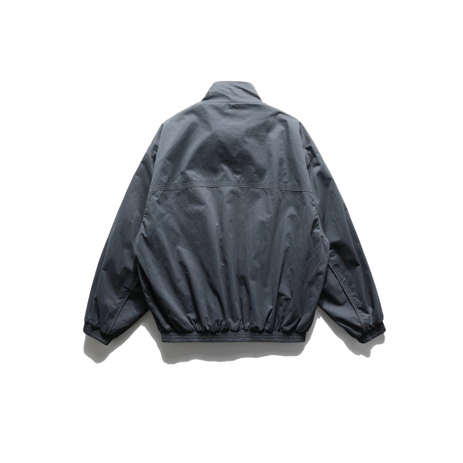 Back view of a dark charcoal jacket with a stand collar, long sleeves, and elastic cuffs and hem.