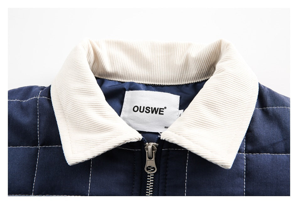 Close-up of a navy quilted jacket's cream corduroy collar, zipper, and sewn-in label.
