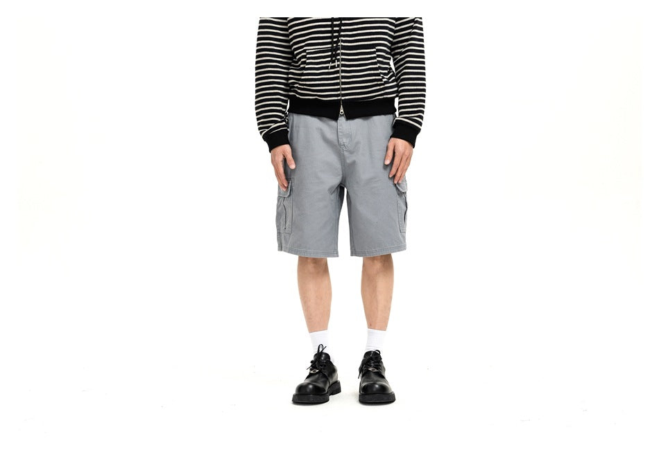 Model wearing light gray cargo shorts with side pockets, shown from the front.
