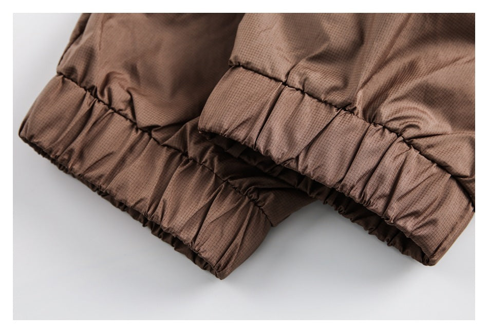 Close-up of gathered elastic edges on a brown garment with a fine grid pattern.