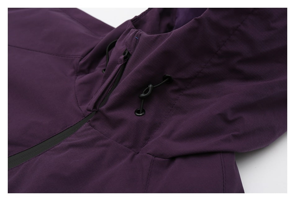 Close-up of the jacket's deep-purple fabric, black drawcord toggles, and zipper area.