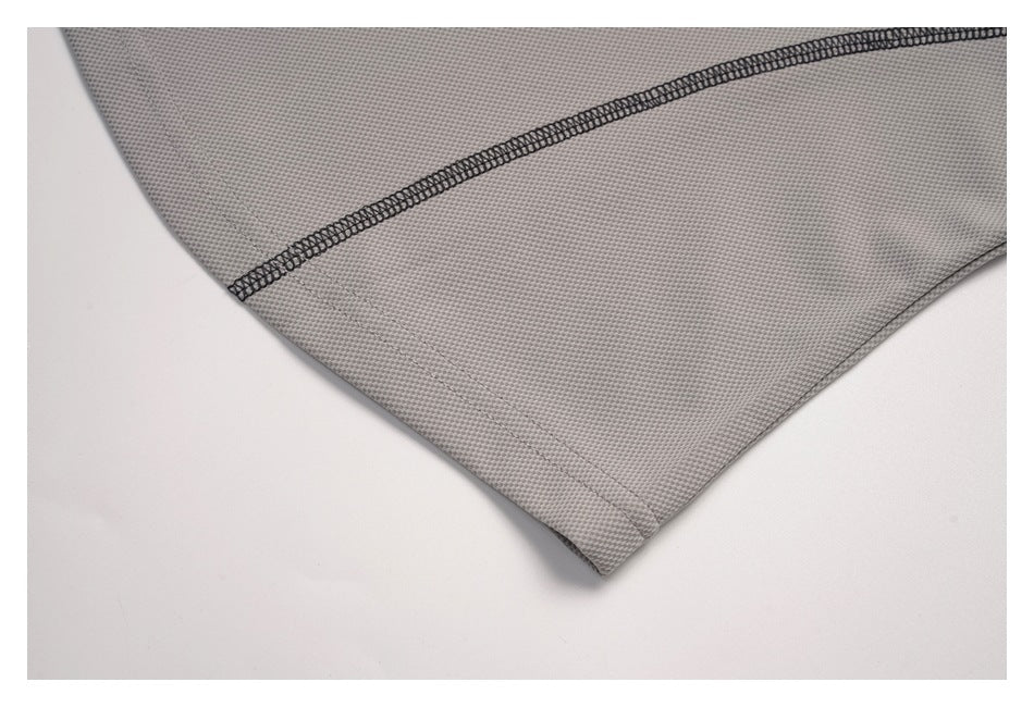 Close-up of a light gray garment hem and dark overlock seam.