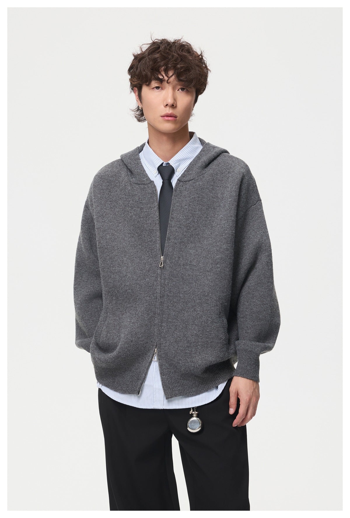 Model wearing a charcoal gray zip-front hooded cardigan over a striped shirt and tie.