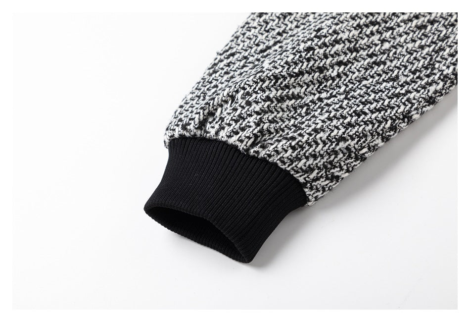 Close-up of a black ribbed cuff on a black-and-white patterned sleeve.