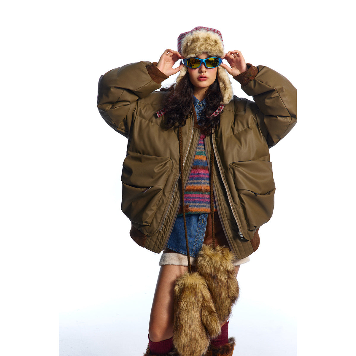 Front view of a model in an oversized olive-brown puffer jacket with large pockets and a front zip.
