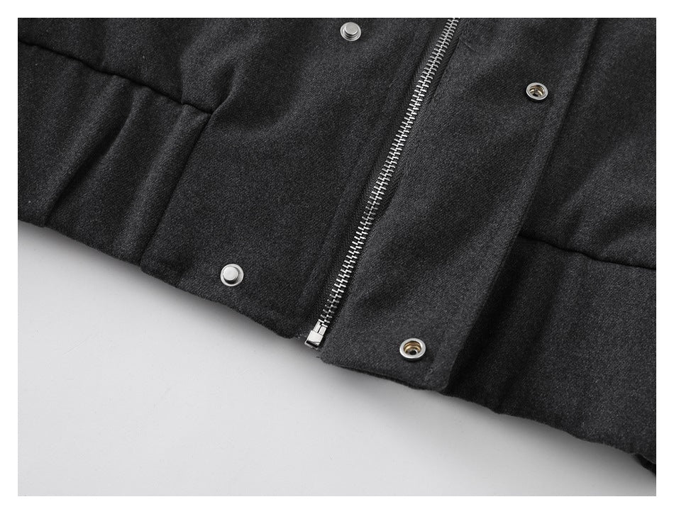 Close-up of the charcoal coat front with a metal zipper and snap fasteners.