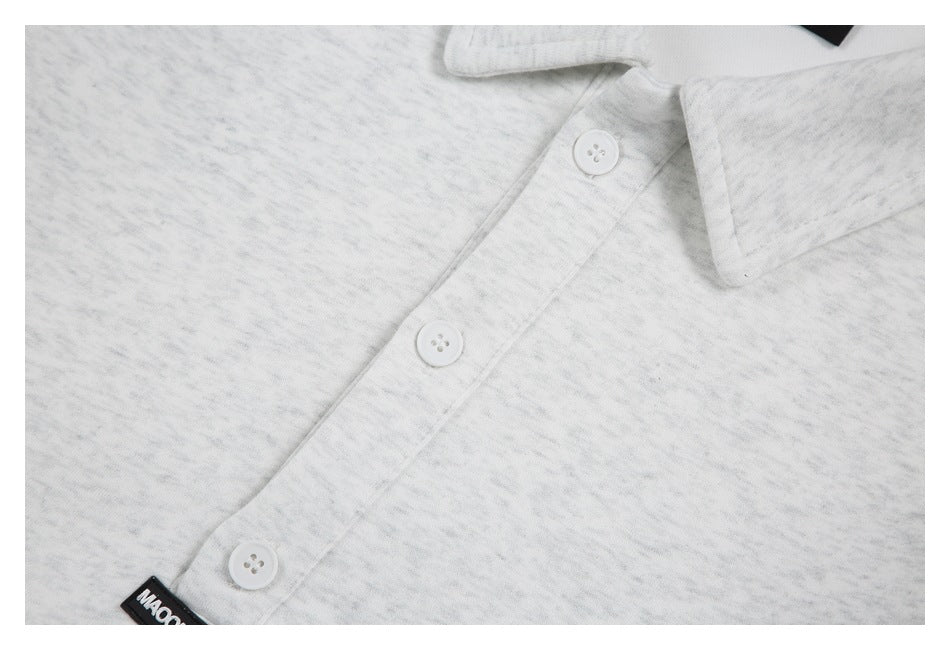 Close-up of the light gray heather shirt’s three-button placket and pointed collar edge.