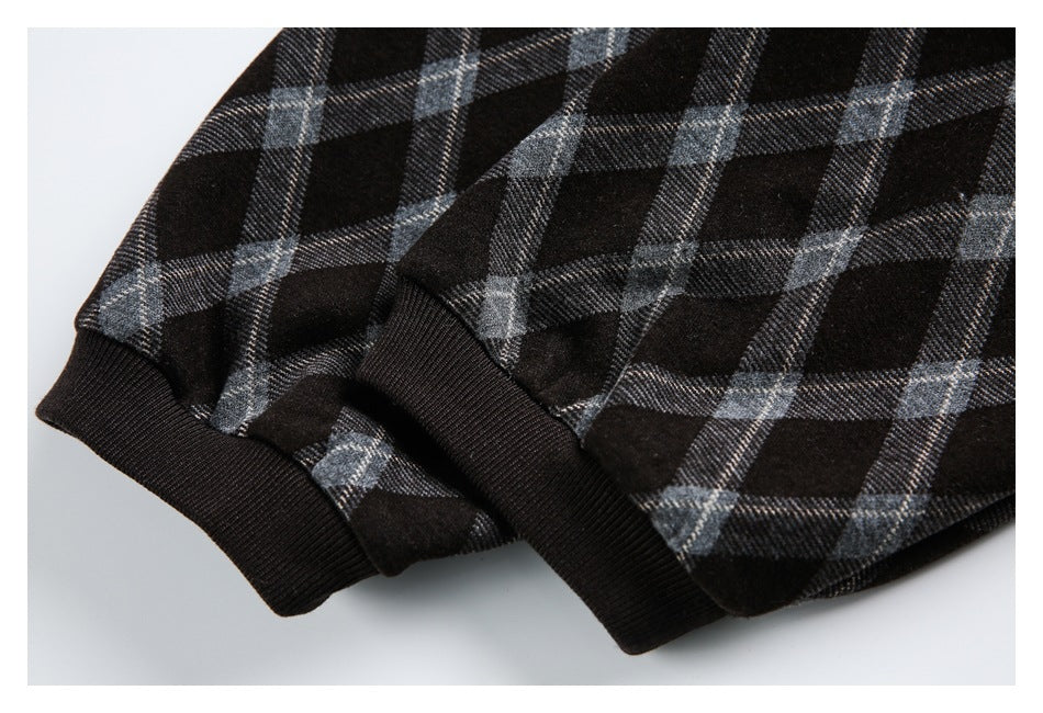 Close-up of two dark ribbed cuffs on a garment with a gray plaid pattern.