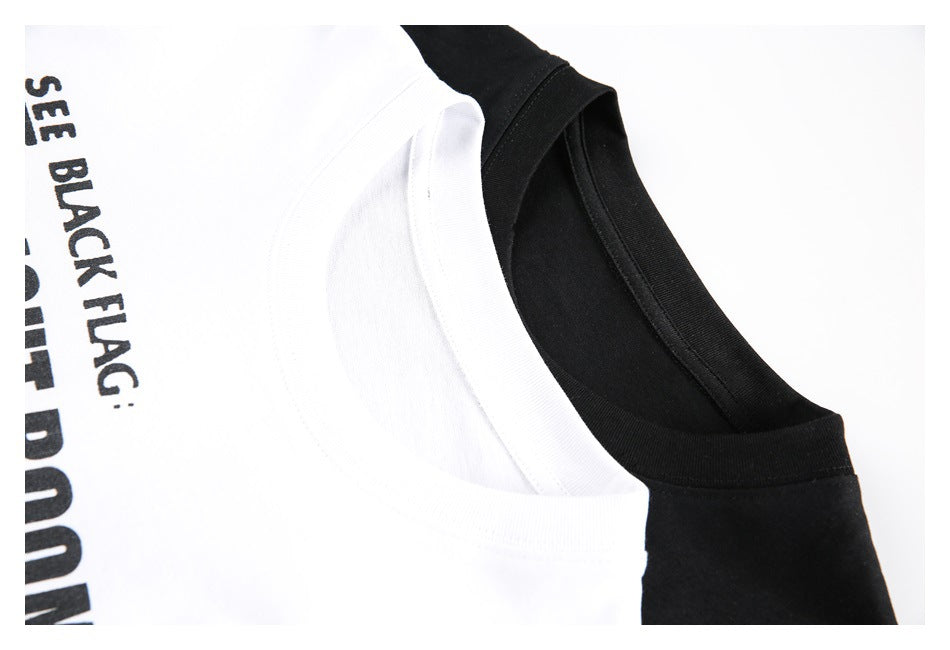 Close-up of overlapping white and black T-shirt crew necks; partial black lettering appears on the white shirt.