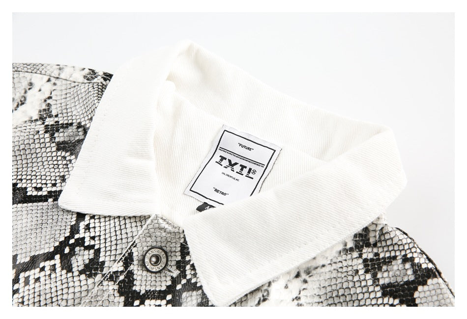 Close-up of an off-white jacket's wide collar, sewn-in label, metal snap, and snakeskin-print panel.