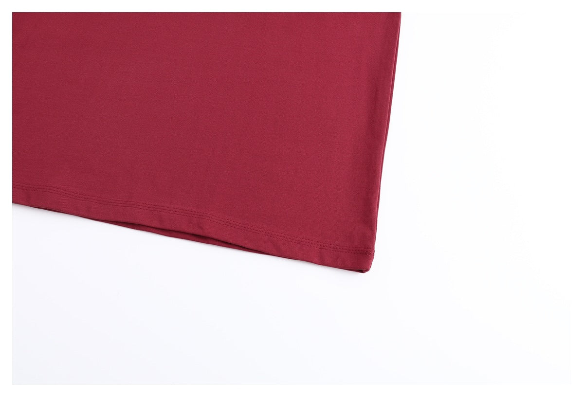 Close-up of the plain burgundy T-shirt body and double-stitched bottom hem.