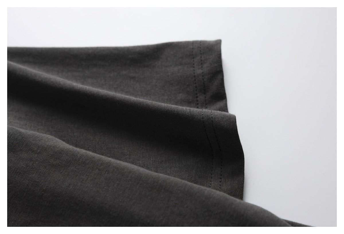 Close-up of the charcoal shirt fabric folded to show a stitched edge.
