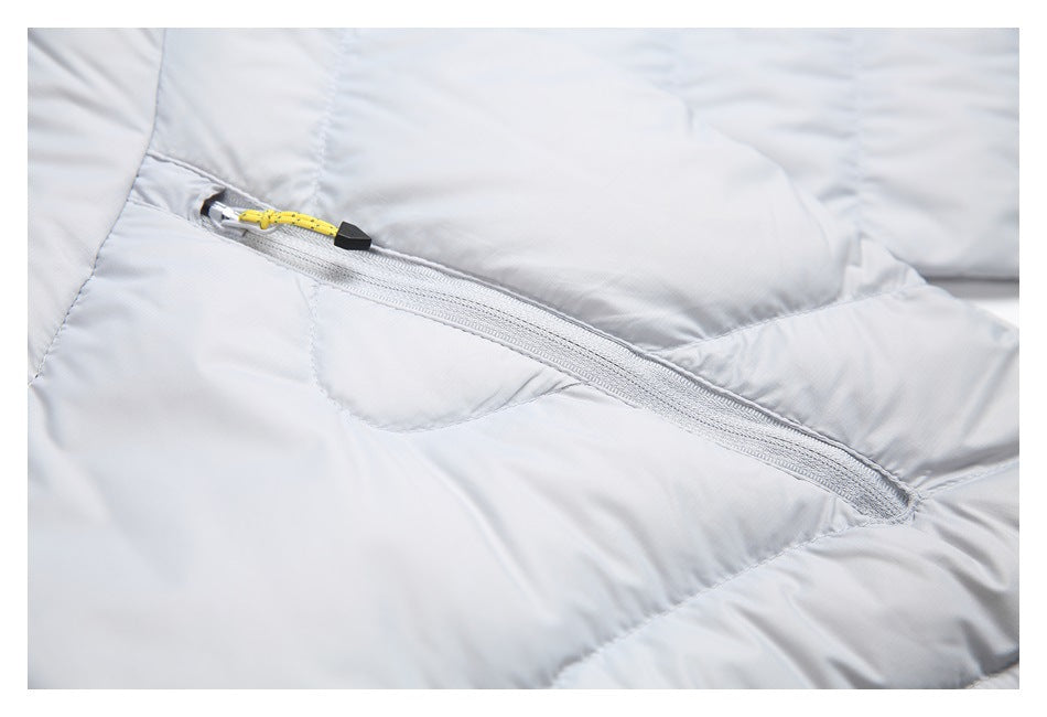 Diagonal zip pocket on a light gray quilted jacket, finished with a yellow cord pull and black toggle.
