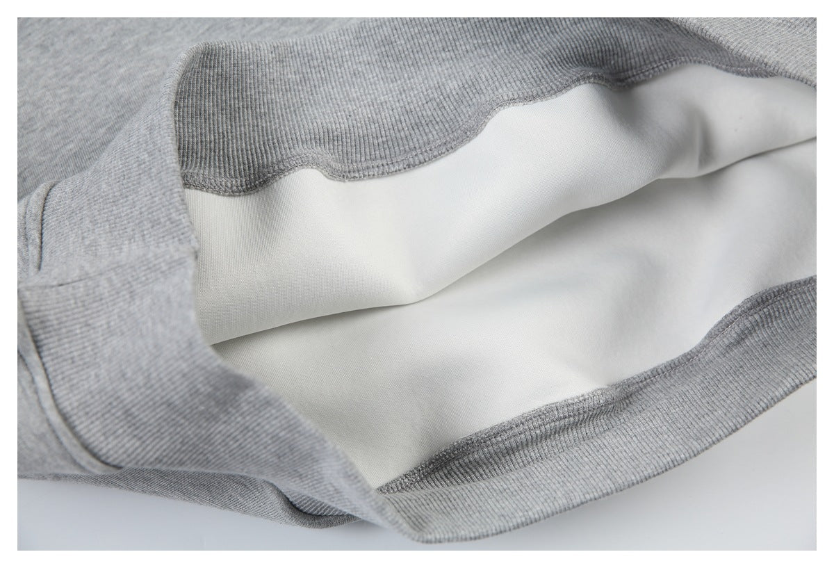 Close-up of a gray ribbed garment edge opened to show the smooth white inner lining.
