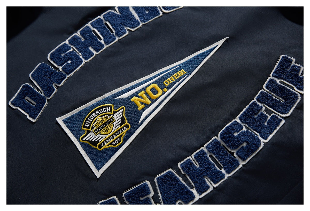 Close-up of a navy jacket with raised lettering and a triangular embroidered patch in blue, white, and yellow.