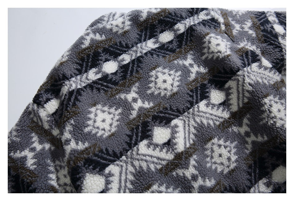 Close-up showing the garment's gray, black, white, and brown geometric fleece pattern.