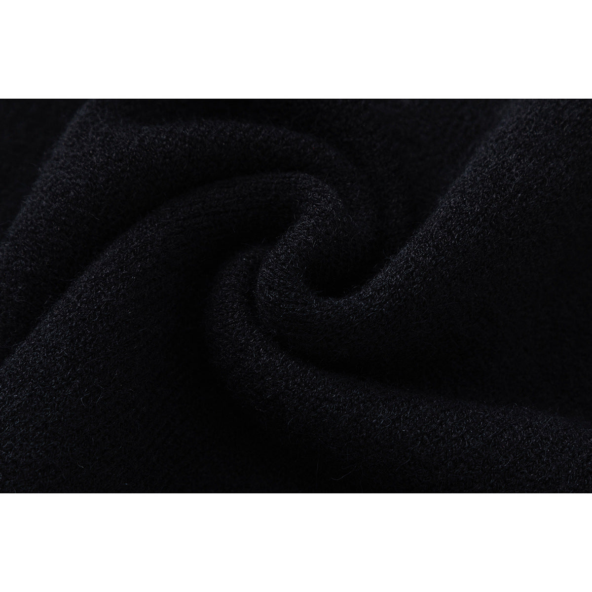 Close-up of the dark, textured knit surface of a black sweater.