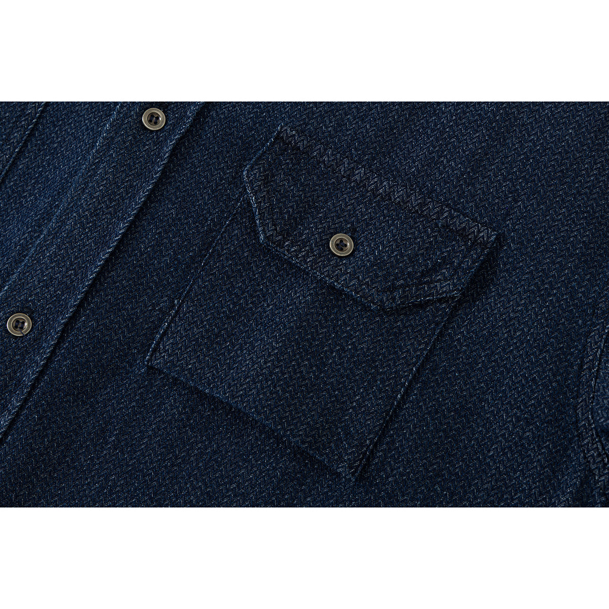 Close-up of a dark blue patterned shirt's buttoned chest pocket.