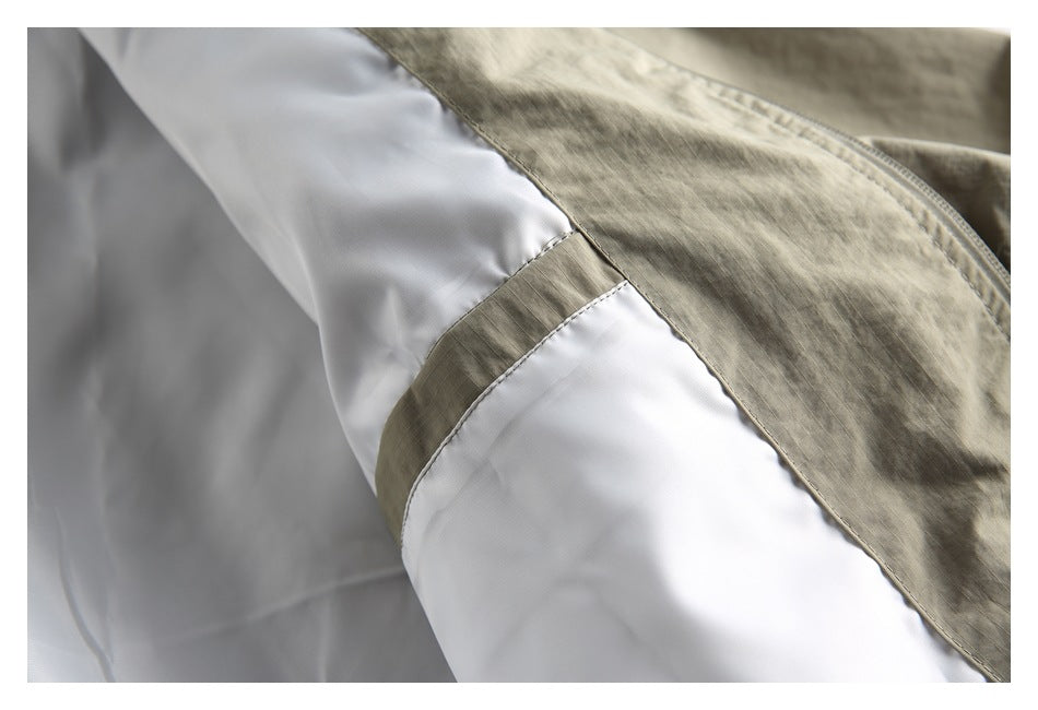 Close-up of the jacket's khaki outer fabric, white lining, and joining seam.