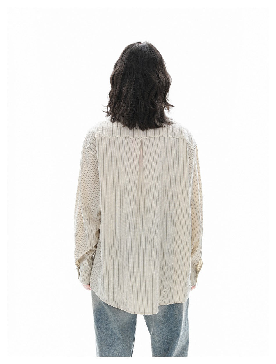 Rear view of a person wearing the ivory thin-striped button-up shirt with blue jeans.