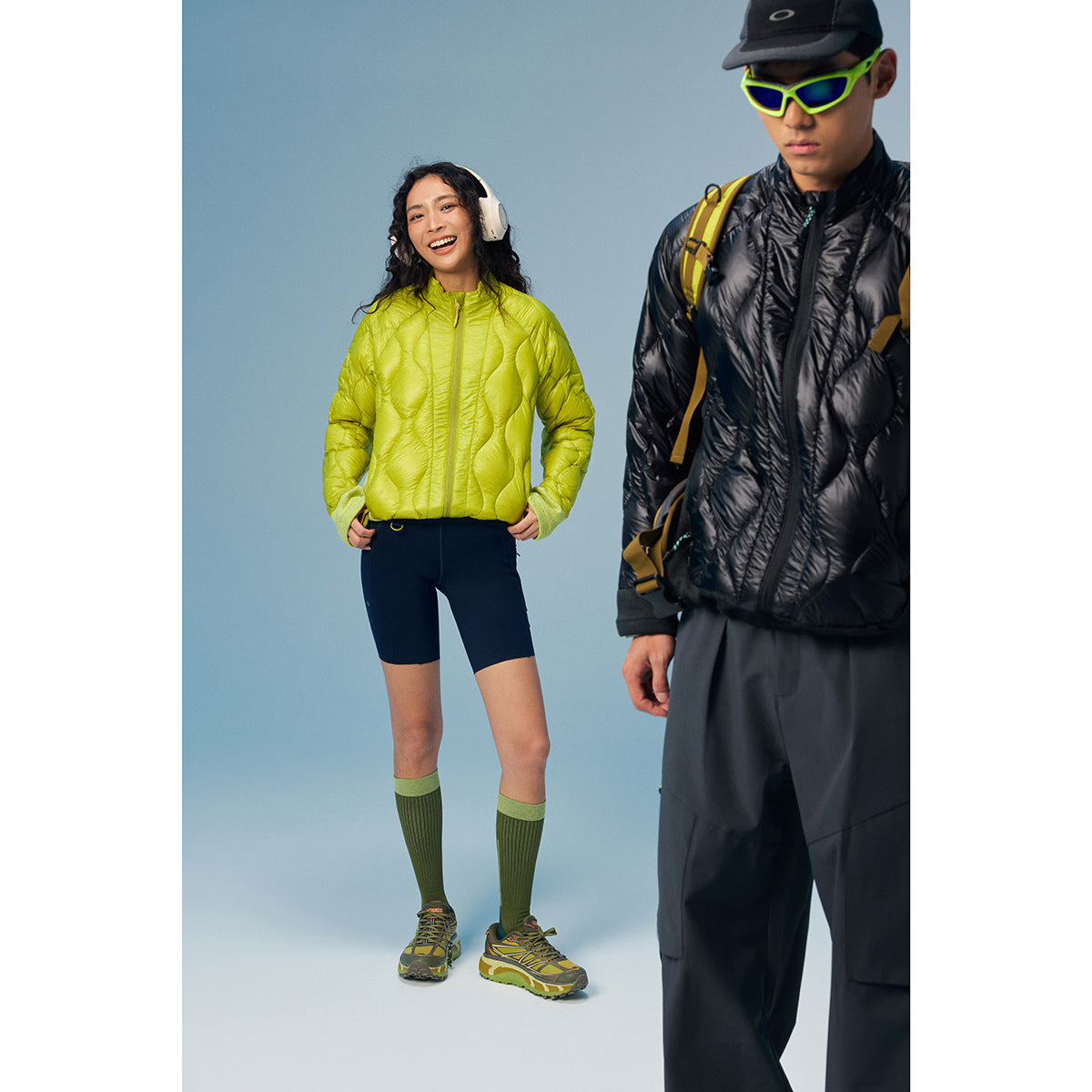 Two models wear quilted zip jackets: a lime-green jacket with contrasting sleeves and a black jacket.