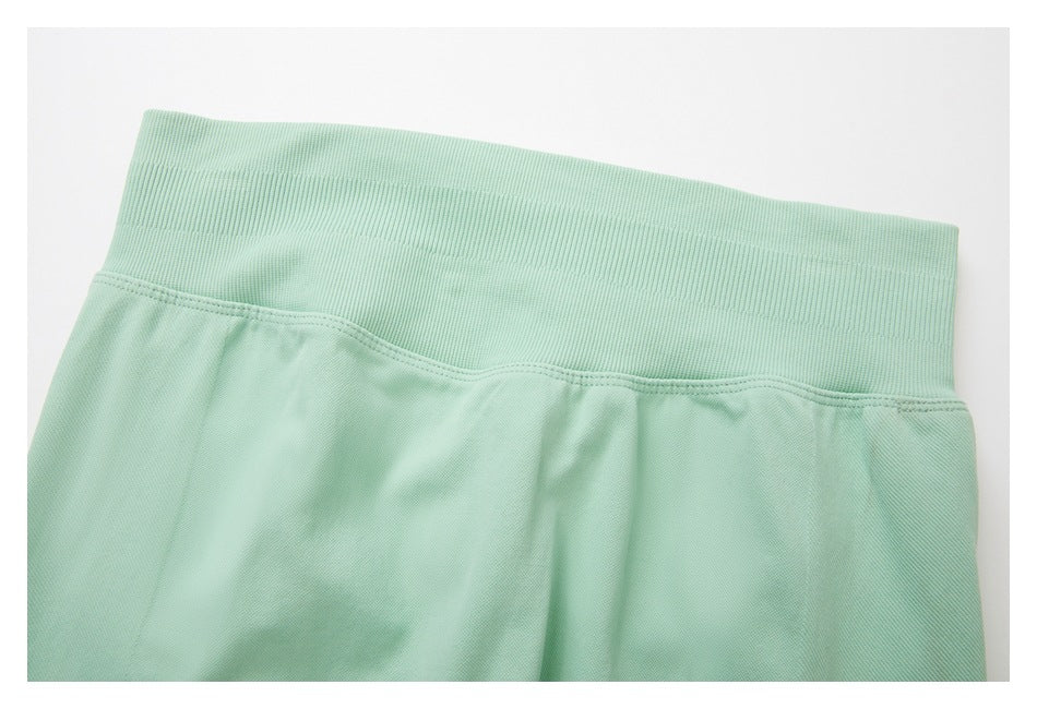 Close-up of the mint-green leggings’ wide ribbed waistband and upper seam.