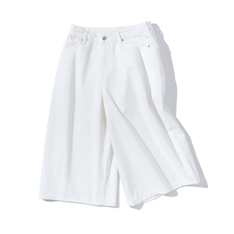 White wide-leg knee-length shorts laid at an angle showing waistband, fly and wide legs